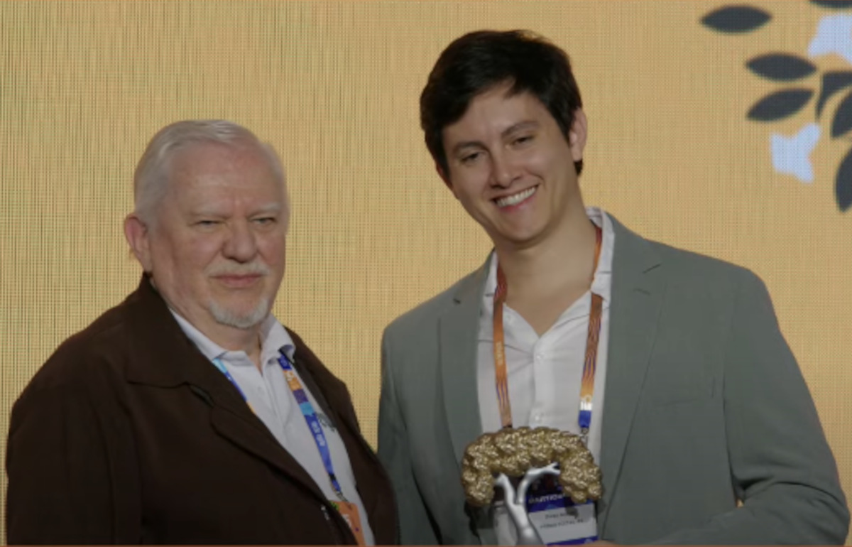 Diego Aquino, filho de Miriam Aquino, recebe homenagem à mãe do Fórum da Internet do Brasil. Troféu foi entregue por Hartmut Glazer, do CGI.br
