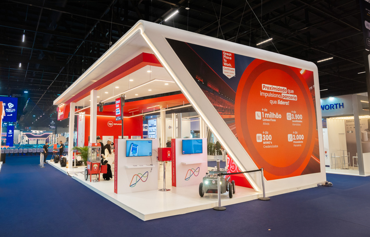 Stand TIP Brasil na Abrint 2025, mostrando a solução de MVNO no telão de LED do evento. 